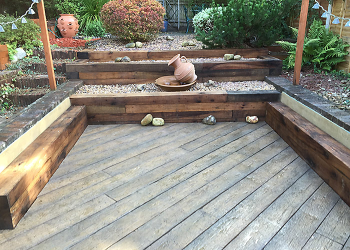 Photo of new completed patio with sleeper edges and wood effect  paving