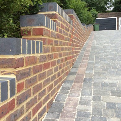 Image of new wall with two-tone brickwork and driveway